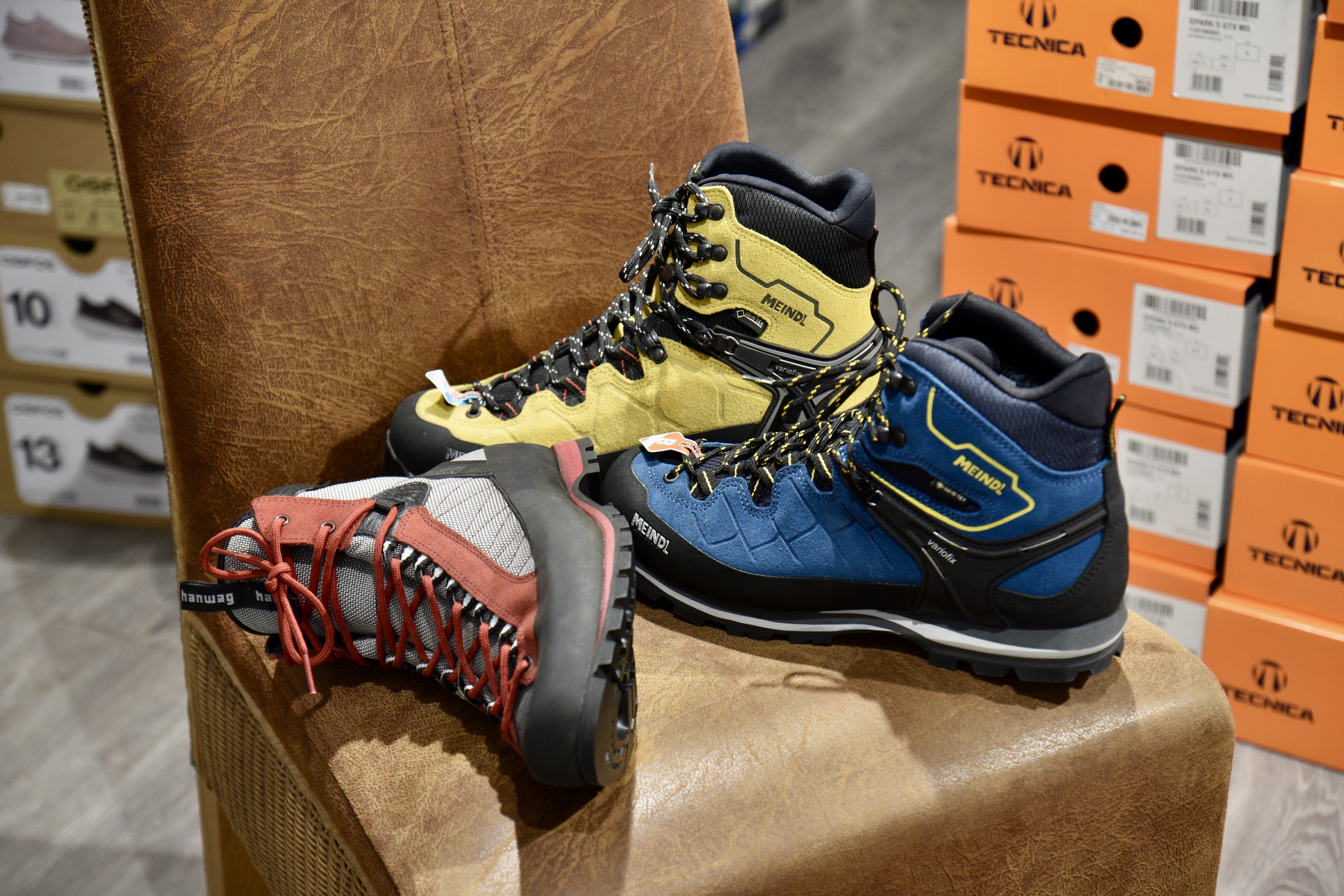 Auswahl an Wanderschuhen von Meindl und Hanwag auf einem Ledersessel